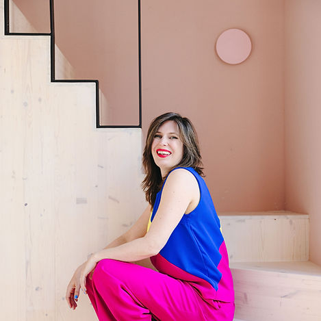 Moderator Maaike Muis in kleurrijke outfit op een trap
